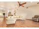 Bright living room featuring wood floors, a ceiling fan and plenty of natural light at 9121 W Quail W Trl, Queen Creek, AZ 85144