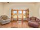 Inviting living room with wood floors and French doors leading to the backyard at 9121 W Quail W Trl, Queen Creek, AZ 85144