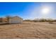 A detached outbuilding with a garage door on a large, rural property with clear blue skies above at 9121 W Quail W Trl, Queen Creek, AZ 85144