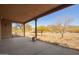 Spacious covered patio overlooking a natural desert landscape with mature trees and scenic mountain views at 9121 W Quail W Trl, Queen Creek, AZ 85144