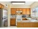 Traditional kitchen features wood cabinets, tile backsplash, and stainless steel refrigerator at 931 W Hermosa Dr, Tempe, AZ 85282