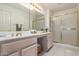 Well-lit bathroom featuring a double vanity, a large mirror, and a glass-enclosed shower at 9521 E Hercules Dr, Sun Lakes, AZ 85248