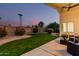 Inviting backyard with green grass, desert landscaping, and covered patio with seating area at 1003 W Aire Libre Ave, Phoenix, AZ 85023