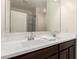Bathroom vanity featuring double sinks, white countertops, dark cabinets, and a large mirror at 101 W Seven Seas Dr, Casa Grande, AZ 85122