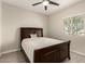 Cozy bedroom with a comfortable bed, wood-look tile flooring, and natural light from a window at 101 W Seven Seas Dr, Casa Grande, AZ 85122