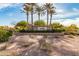 Stone-lined 'Villago' community sign featuring palm trees and manicured landscaping, under a bright, sunny sky at 101 W Seven Seas Dr, Casa Grande, AZ 85122