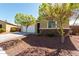 Charming single-story home showcasing a two-car garage, desert landscaping, and stone accents at 101 W Seven Seas Dr, Casa Grande, AZ 85122