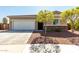 Charming single-story home showcasing a two-car garage, desert landscaping, and stone accents at 101 W Seven Seas Dr, Casa Grande, AZ 85122