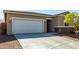 Charming single-story home showcasing a two-car garage, desert landscaping, and stone accents at 101 W Seven Seas Dr, Casa Grande, AZ 85122
