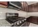 Close-up of the stainless steel oven and microwave, granite countertops, and tile backsplash at 101 W Seven Seas Dr, Casa Grande, AZ 85122