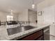Kitchen island featuring a stainless steel sink, granite countertop, and dark cabinets at 101 W Seven Seas Dr, Casa Grande, AZ 85122