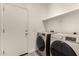 A laundry room with modern washer and dryer units, shelf, and access door at 101 W Seven Seas Dr, Casa Grande, AZ 85122