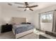 Bright main bedroom with a large window, ceiling fan, wood-look tile floors, and neutral decor at 101 W Seven Seas Dr, Casa Grande, AZ 85122