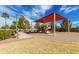 Community playground featuring colorful equipment, sunshade, and benches, set against a partly cloudy blue sky at 101 W Seven Seas Dr, Casa Grande, AZ 85122