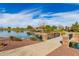 Scenic pond with pedestrian bridge, walking path and lakeside gazebo, providing a tranquil community amenity at 101 W Seven Seas Dr, Casa Grande, AZ 85122