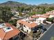 Scenic aerial view of townhomes with red tile roofs nestled near mountains and lush landscaping at 10224 N 12Th Pl # 1, Phoenix, AZ 85020