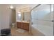 Bright bathroom featuring a double sink vanity, large mirror, and glass enclosed shower and tub combination at 10224 N 12Th Pl # 1, Phoenix, AZ 85020