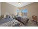 Comfortable bedroom with two beds, a ceiling fan, and a bright window with neighborhood views at 10224 N 12Th Pl # 1, Phoenix, AZ 85020