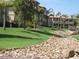 Beautiful multi-story building exterior surrounded by vibrant green landscaping, rock feature, and trees at 10224 N 12Th Pl # 1, Phoenix, AZ 85020