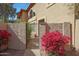 Condo exterior showcasing a private gate, desert landscaping with bougainvillea, and stucco walls at 10224 N 12Th Pl # 1, Phoenix, AZ 85020