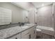 Bathroom featuring granite countertop, modern fixtures, and tub/shower combo at 10281 N 115Th Ave, Youngtown, AZ 85363