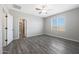 Bedroom boasts wood-look floors, a ceiling fan, and an en suite bathroom with walk in shower at 10281 N 115Th Ave, Youngtown, AZ 85363