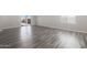 Spacious living room with stylish gray wood flooring and sliding door access to the backyard at 10281 N 115Th Ave, Youngtown, AZ 85363