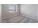 Cozy bedroom with neutral carpet, white trim, and a window for natural light at 10353 N 115Th Ave, Youngtown, AZ 85363