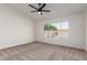 Bedroom with neutral carpet, a ceiling fan, and a window overlooking the backyard at 11951 N 69Th Ave, Peoria, AZ 85345