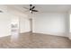 Spacious living room with wood-look tile flooring and a ceiling fan at 11951 N 69Th Ave, Peoria, AZ 85345