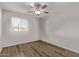 Bedroom featuring a ceiling fan, wood-look flooring, and a window with bright natural light at 12211 N 25Th Ave, Phoenix, AZ 85029