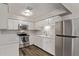 Charming kitchen with stainless steel appliances, white cabinets, and dark wood flooring at 12211 N 25Th Ave, Phoenix, AZ 85029