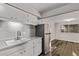 Kitchen sink and stainless steel refrigerator with white cabinetry and flooring at 12211 N 25Th Ave, Phoenix, AZ 85029