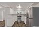 Well-lit kitchen with stainless steel appliances, white cabinets, and durable flooring at 12211 N 25Th Ave, Phoenix, AZ 85029