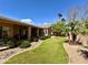 Spacious backyard with a covered patio, manicured lawn, and desert landscaping, offering a private outdoor oasis at 1339 N Tucana Ln, Gilbert, AZ 85234