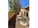 Side yard with a gravel pathway, mature tree, and privacy wall, offering functional outdoor space at 1339 N Tucana Ln, Gilbert, AZ 85234