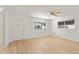 Bright living room featuring hardwood floors, white walls, ceiling fan, and large window at 1404 E Hall St, Tempe, AZ 85281