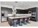 Modern kitchen featuring stainless steel appliances, a large island with seating, and sleek black cabinetry at 14194 W Sand Hills Rd, Surprise, AZ 85387