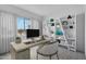 Bright home office with a large window, stylish desk, and modern shelving for organized storage at 14194 W Sand Hills Rd, Surprise, AZ 85387