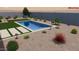 A backyard pool is surrounded by lush landscaping and decorative stone at 14741 N 73Rd Dr, Peoria, AZ 85381
