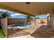 Covered back patio provides shade and features a stone floor, showcasing the inviting pool at 1588 S 226Th Dr, Buckeye, AZ 85326