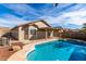 Inviting backyard pool with a safety fence, complemented by lush landscaping and a clear blue sky at 1588 S 226Th Dr, Buckeye, AZ 85326