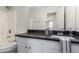 Bright bathroom with a single sink vanity, dark countertop, and a shower/tub combo at 1588 S 226Th Dr, Buckeye, AZ 85326