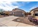Single-story home featuring a two-car garage, desert landscaping, and a private fenced entrance at 1588 S 226Th Dr, Buckeye, AZ 85326