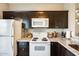 Well-equipped kitchen featuring white appliances, dark cabinets, and natural light at 1600 N Saba St # 177, Chandler, AZ 85225
