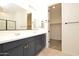 Modern bathroom featuring double sinks with sleek countertops, cabinets, and walk in closet at 1661 N St Francis Pl, Casa Grande, AZ 85122