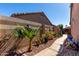 Landscaped backyard featuring a walkway, plants, and privacy wall at 17574 W Gelding Dr, Surprise, AZ 85388
