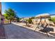 Spacious backyard with a swing set, fountain, and outdoor grilling area at 17574 W Gelding Dr, Surprise, AZ 85388