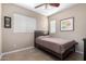 A cozy bedroom with tile flooring, a ceiling fan, and a comfortable bed at 17574 W Gelding Dr, Surprise, AZ 85388