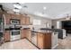 Well-appointed kitchen with stainless steel appliances and an island seamlessly connected to the living room at 17574 W Gelding Dr, Surprise, AZ 85388